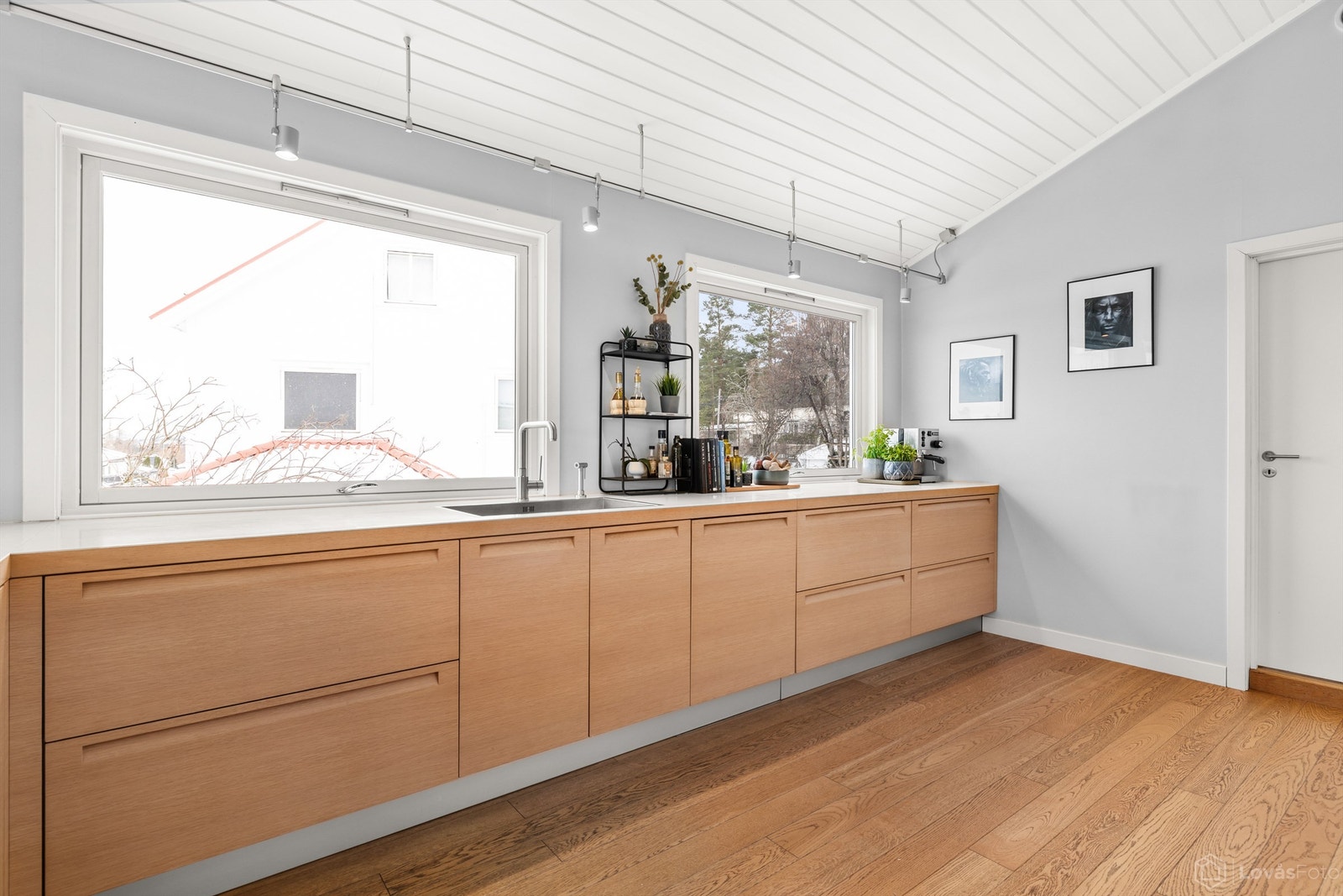 Rikelig med benkeplass og store vinduer gjør kjøkkenet til en lys og funksjonell arbeidsplass. Galleribilde