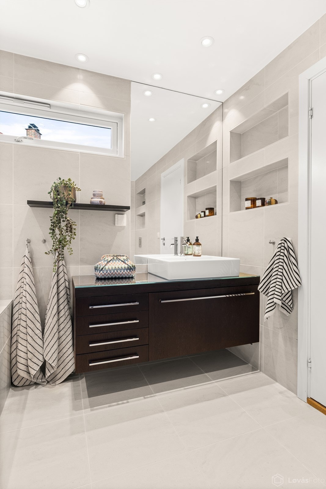 Innredningen har vegghengt servantmøbel, oppgradert med ny servant og armatur i 2025. Galleribilde