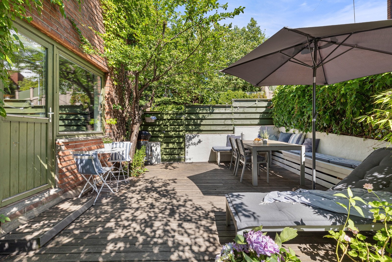Fra stue/kjøkken er det utgang til en stor frodig markterrasse på hele 22 kvm med god plass til grill, sittegrupper og øvrig utemøblement. Samt videre tilgang til hageflekk. Galleribilde