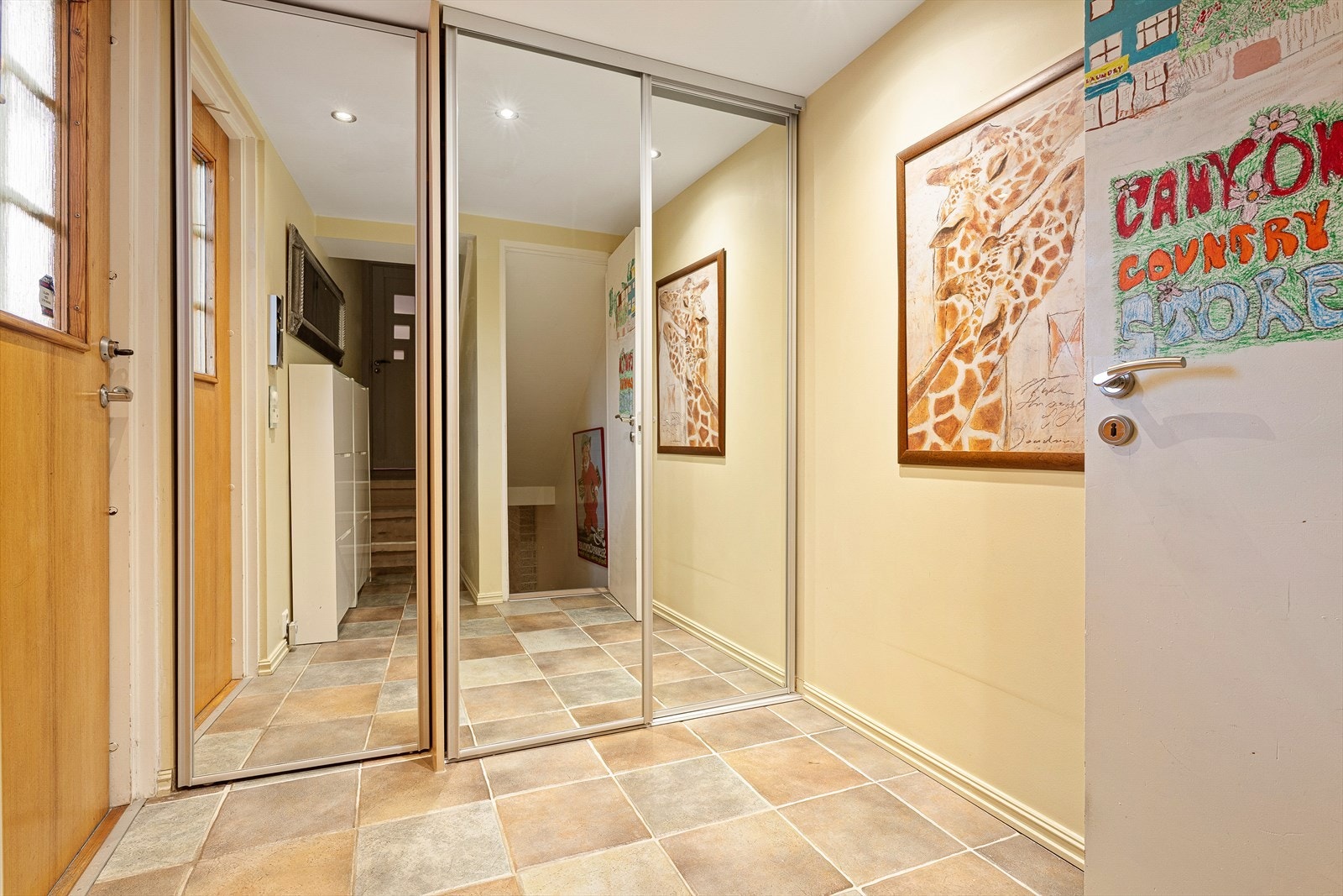 Flislagt gang/entre i 1 etasje med varmekabler i gulv og oppbevaringsplass i skyvedørsgarderobe. Galleribilde