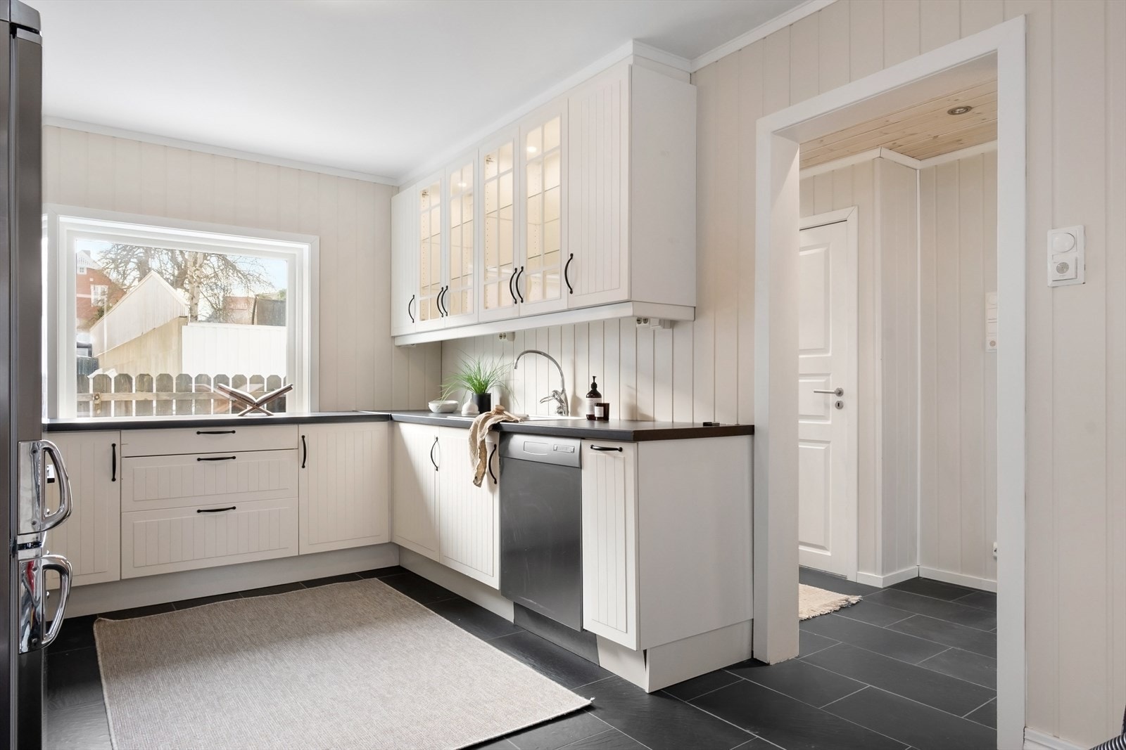 Kjøkkenet ligger i tilknytning til oppholdsrommet, men i et eget rom. Utformingen er praktisk og funksjonell, med tidløs innredning med profilerte fronter og laminat benkeplate. Galleribilde