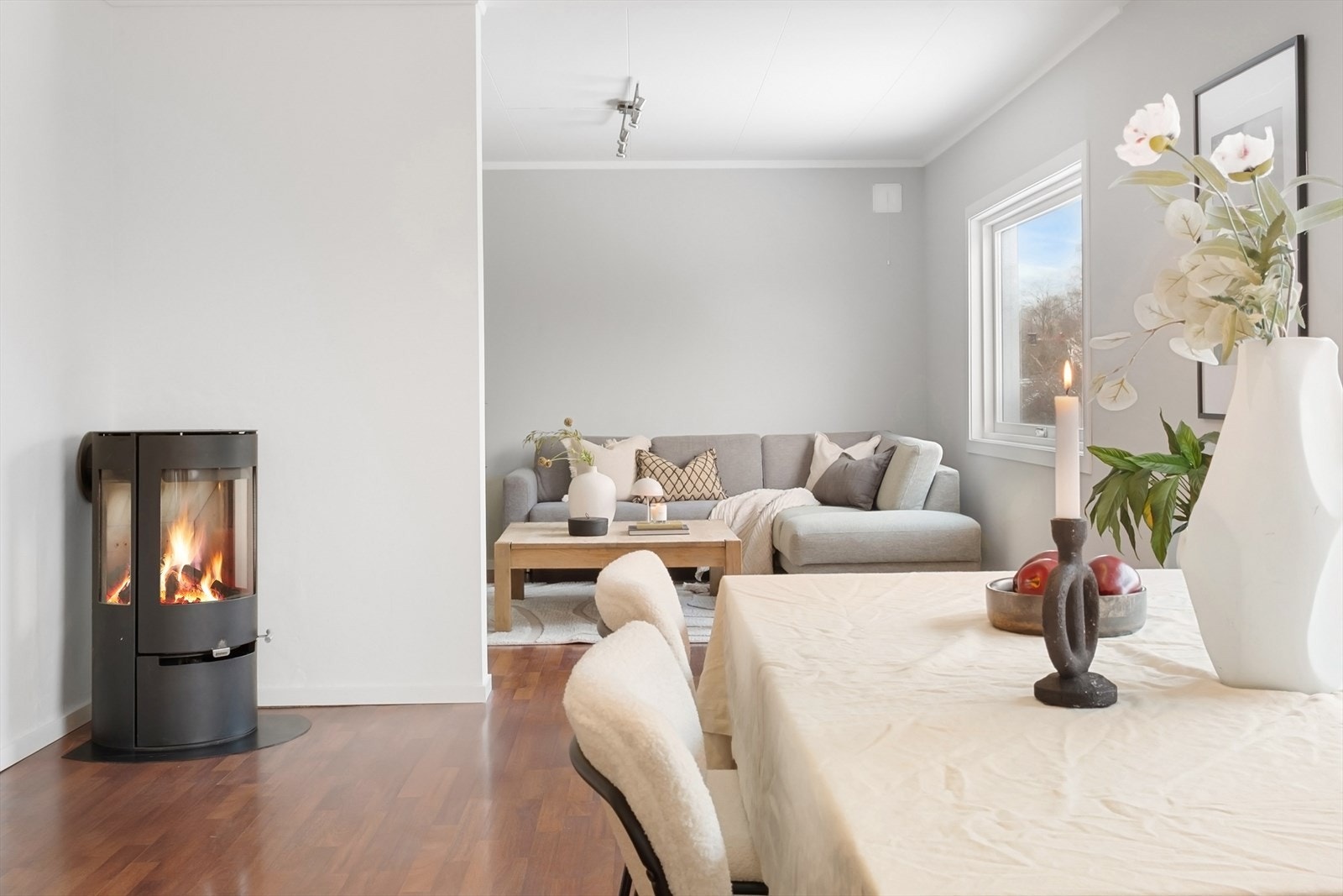 Det er god plass til både sofagruppe, spisebord og vedovn er sentralt plasert i rommet. Galleribilde
