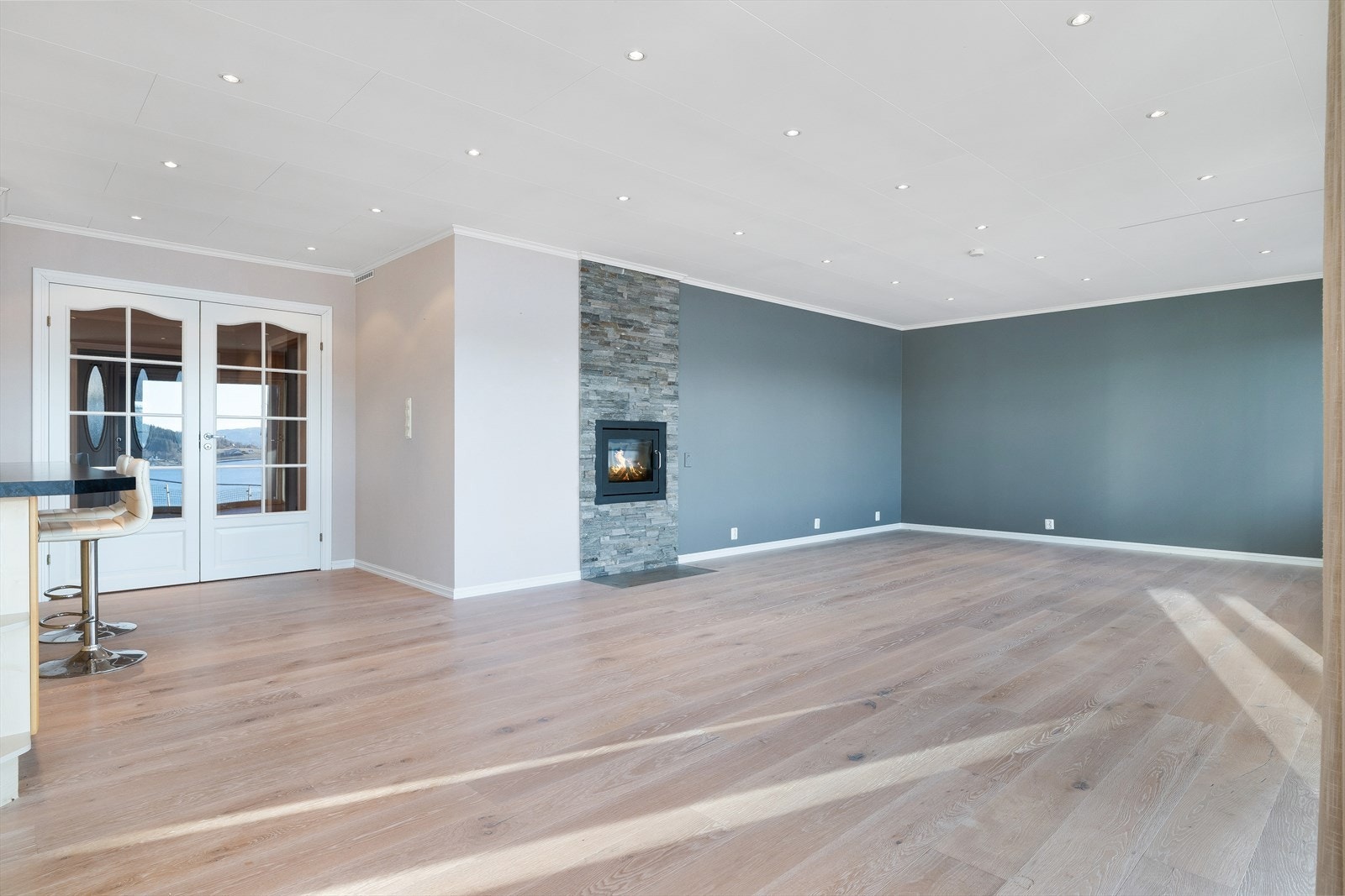 Her kommer du inn til en åpen og lekker stue med smakfulle fargevalg, spotlights i tak og enstavsparkett på gulv. Galleribilde