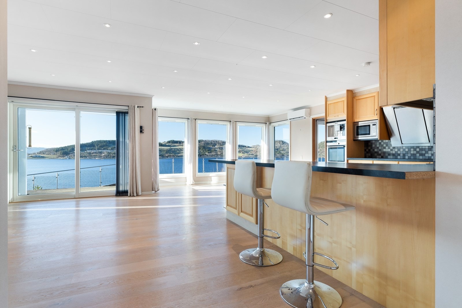 Den innbydende barløsningen skaper en naturlig møteplass for raske frokoster, lekser eller et glass vin mens middagen tilberedes. Galleribilde