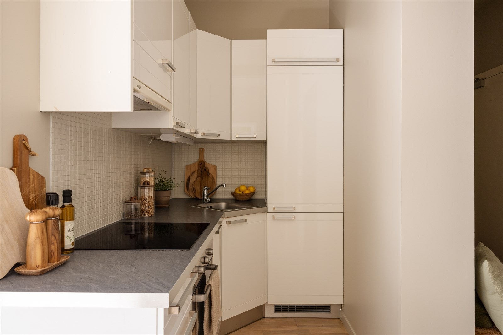 Kjøkkeninnredning med glatte fronter, laminatbenkeplate og integrerte hvitevarer som medfølger salget. Galleribilde