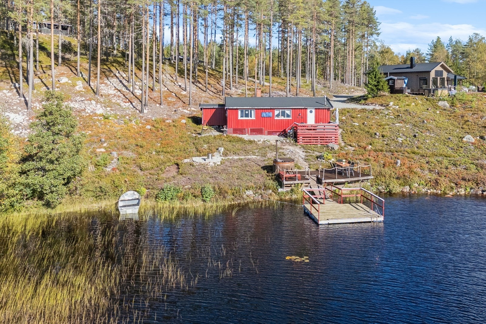 Her ligger hytta idyllisk og usjenert til, omkranset av skog og vann. Galleribilde