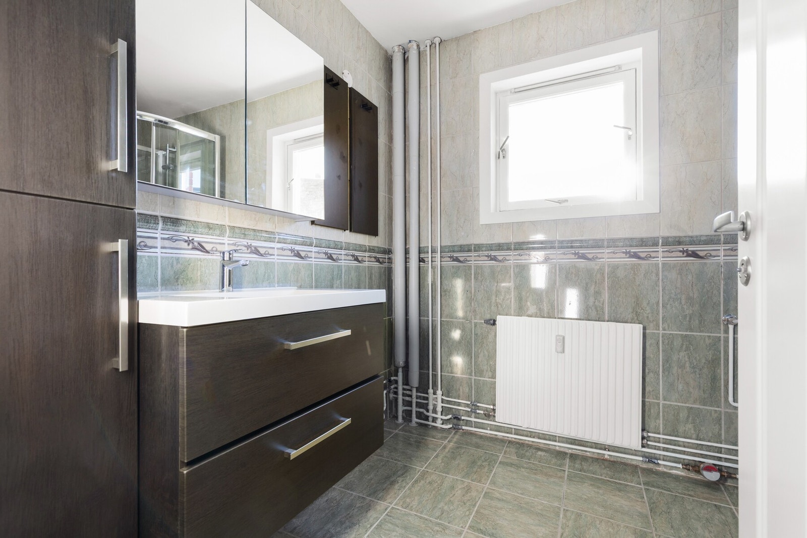 Flislagt baderom med oppvarming fra radiator. Galleribilde