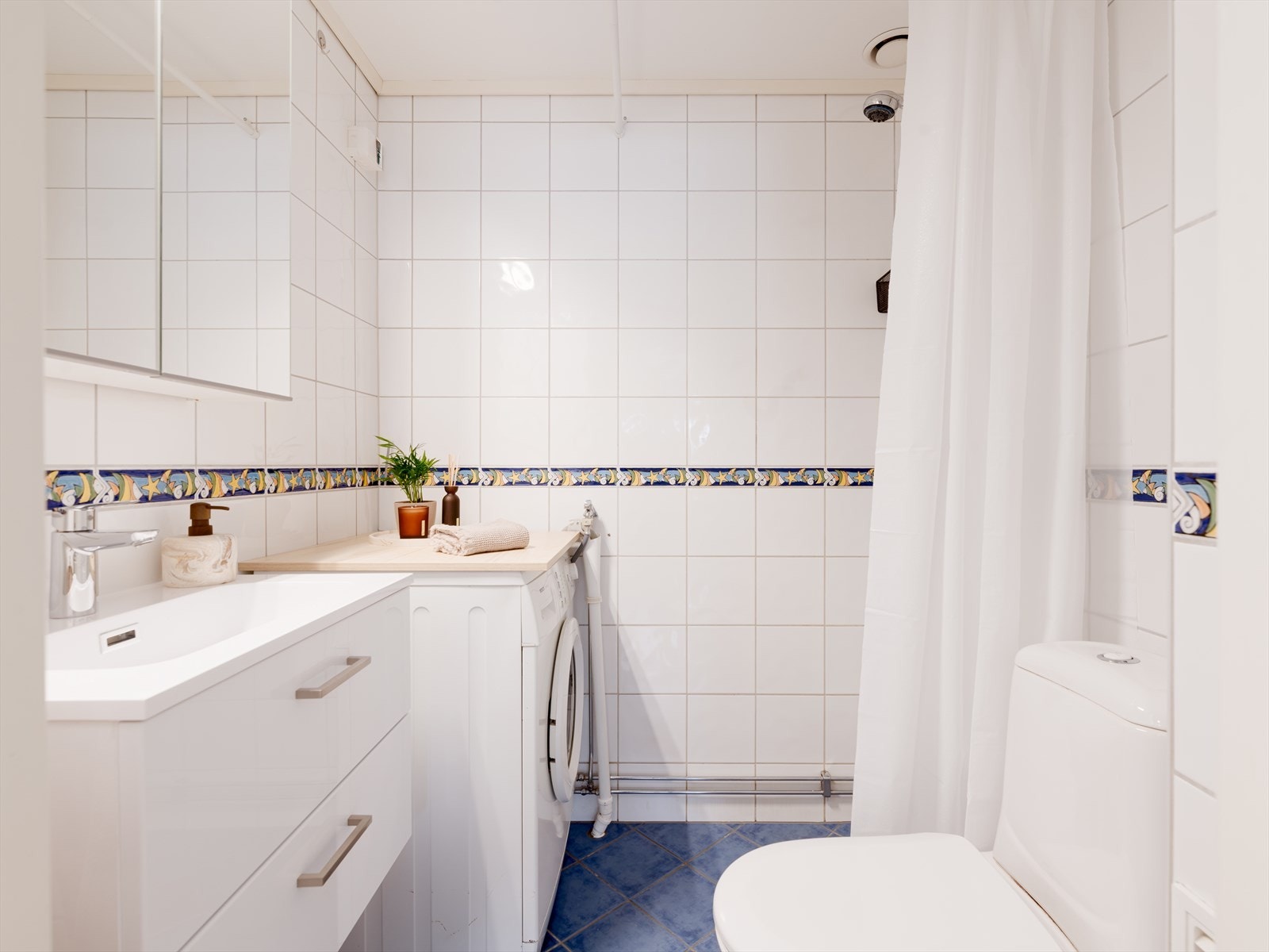 Det er fliser på gulv og vegger. Varmekabel og medfølgende vaskemaskin. Galleribilde