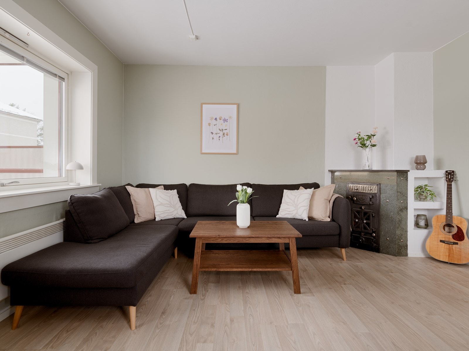 Stuen er romslig. Det er plass til stor hjørnesofa. Klassisk eldre hjørnekamin. Galleribilde