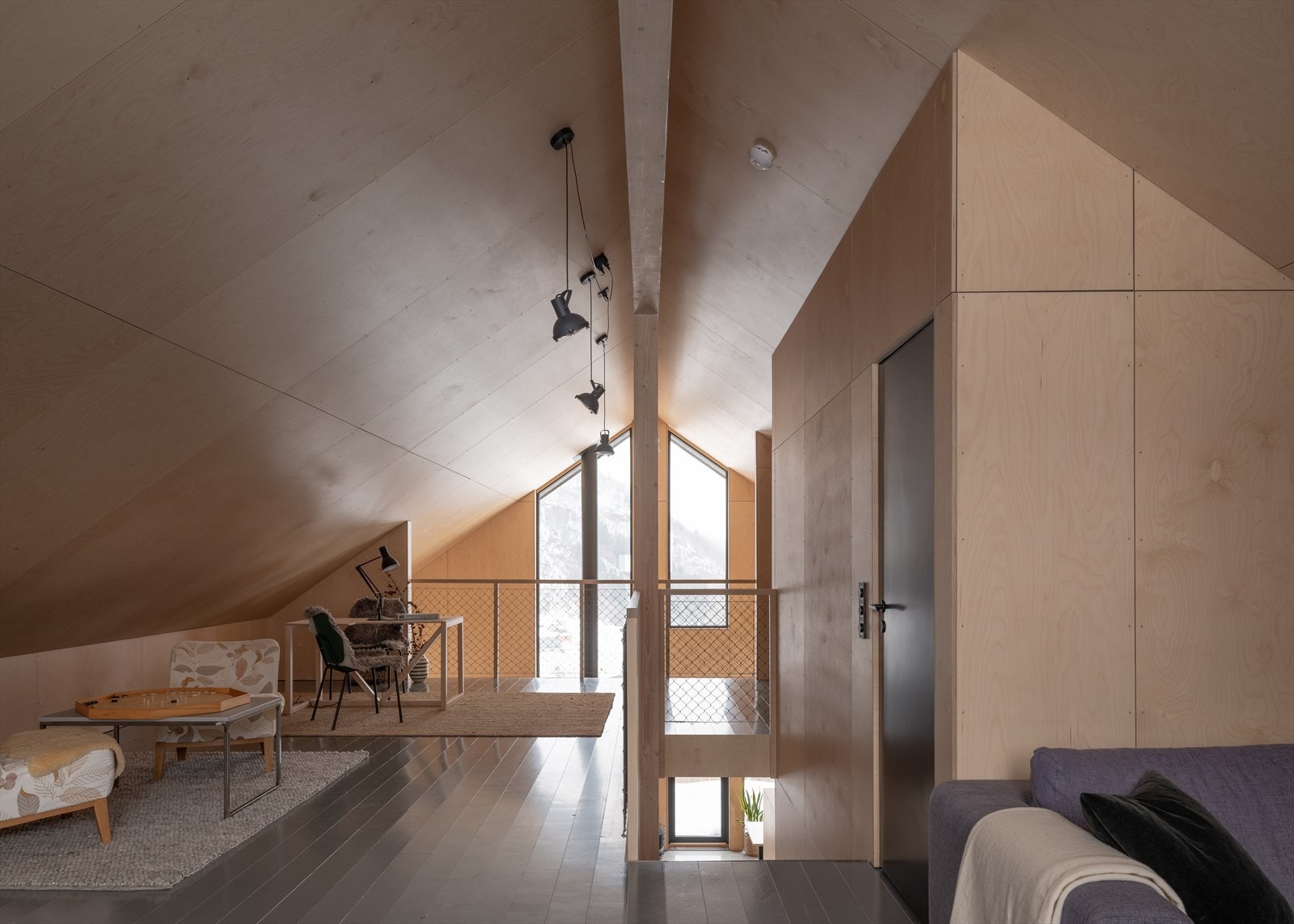 Lys og lun loftsstue med skrå himling og gjennomgående materialbruk. Galleribilde