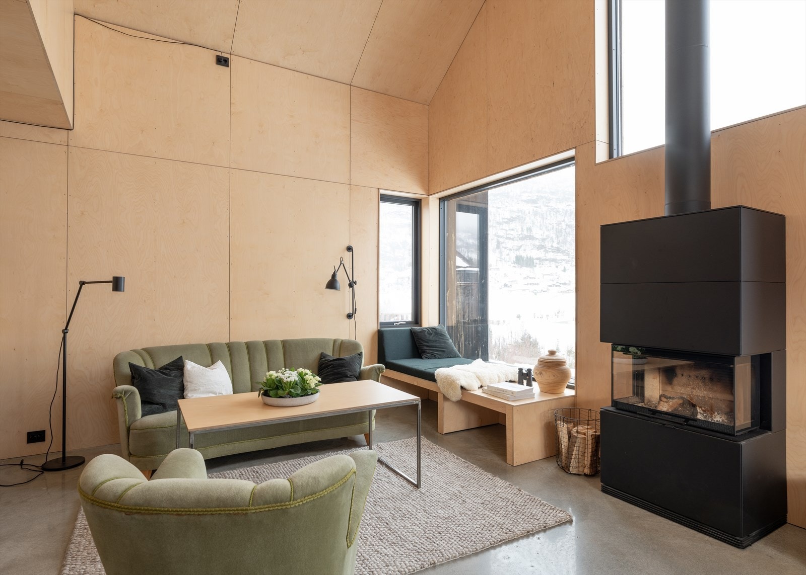 Lys og luftig stue med peis som naturlig blikkfang. Store vindusflater slipper naturen inn og forsterker rommets unike volum og eksklusive preg. Galleribilde