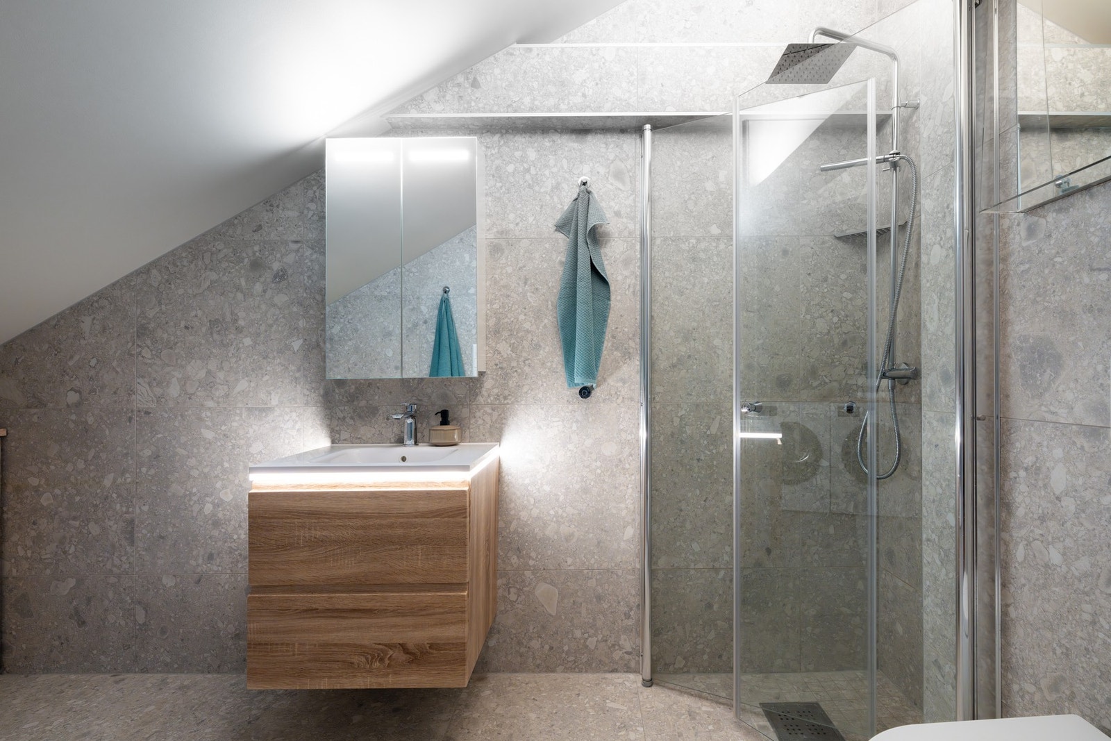 Videre er det dusjhjørne med svingbare glassdører som frigjør plass på gulvet. Galleribilde