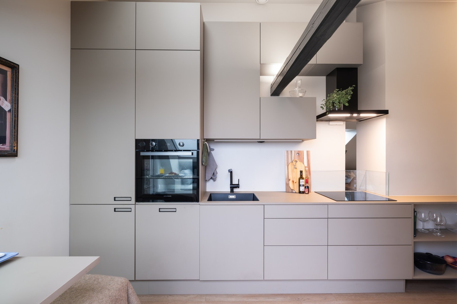 Stilrent Svane kjøkken med glatte fronter, laminat benkeplate og underlimt kjøkkenvask i kompositt. Kjøkkenet er godt utnyttet med mye skap, skuffer og benkeplass. Galleribilde