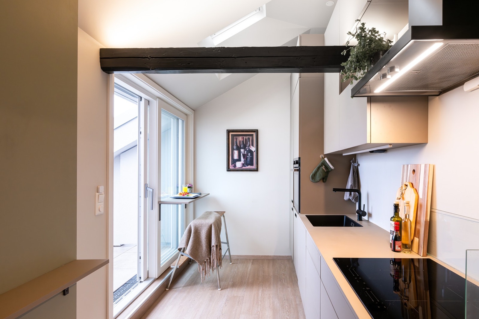 Boligens kjøkken er i en åpen løsning mot stuen, men likevel tilbaketrukket i hjørnet av rommet. Galleribilde