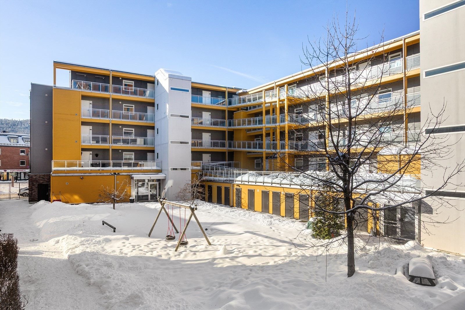 Fellesarealet har sittebenker og lekeplass Galleribilde