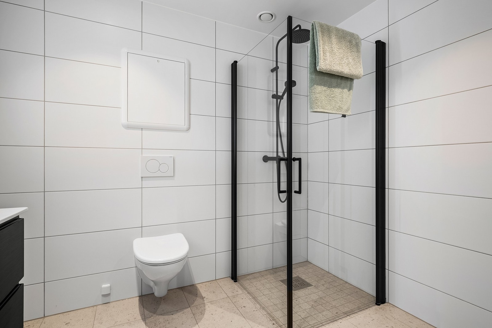 Badet innehar dusjhørne, vegghengt toalett, servant med skuffer og speil med belysning. Varme i gulv. Galleribilde