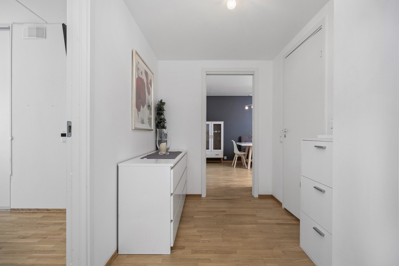 Hvitmalt og romslig entré/gang innredet med god plass til oppbevaringsmøbel etter eget ønske Galleribilde