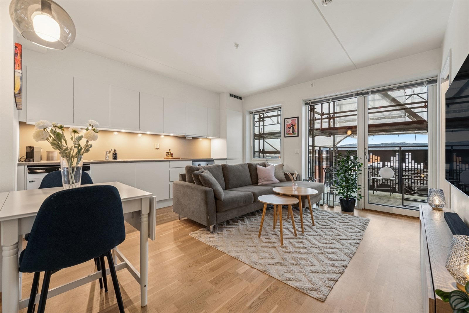 Det er åpen stue og kjøkkenløsning som er arealeffektiv med plass til sofagruppem TV-møblement og spisekrok. Galleribilde