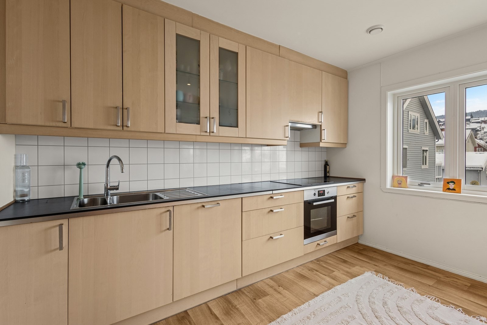 Kjøkkeninnredning med integrert komfyr, koketopp, oppvaskmaskin og kjøleskap medfølger handelen. Galleribilde