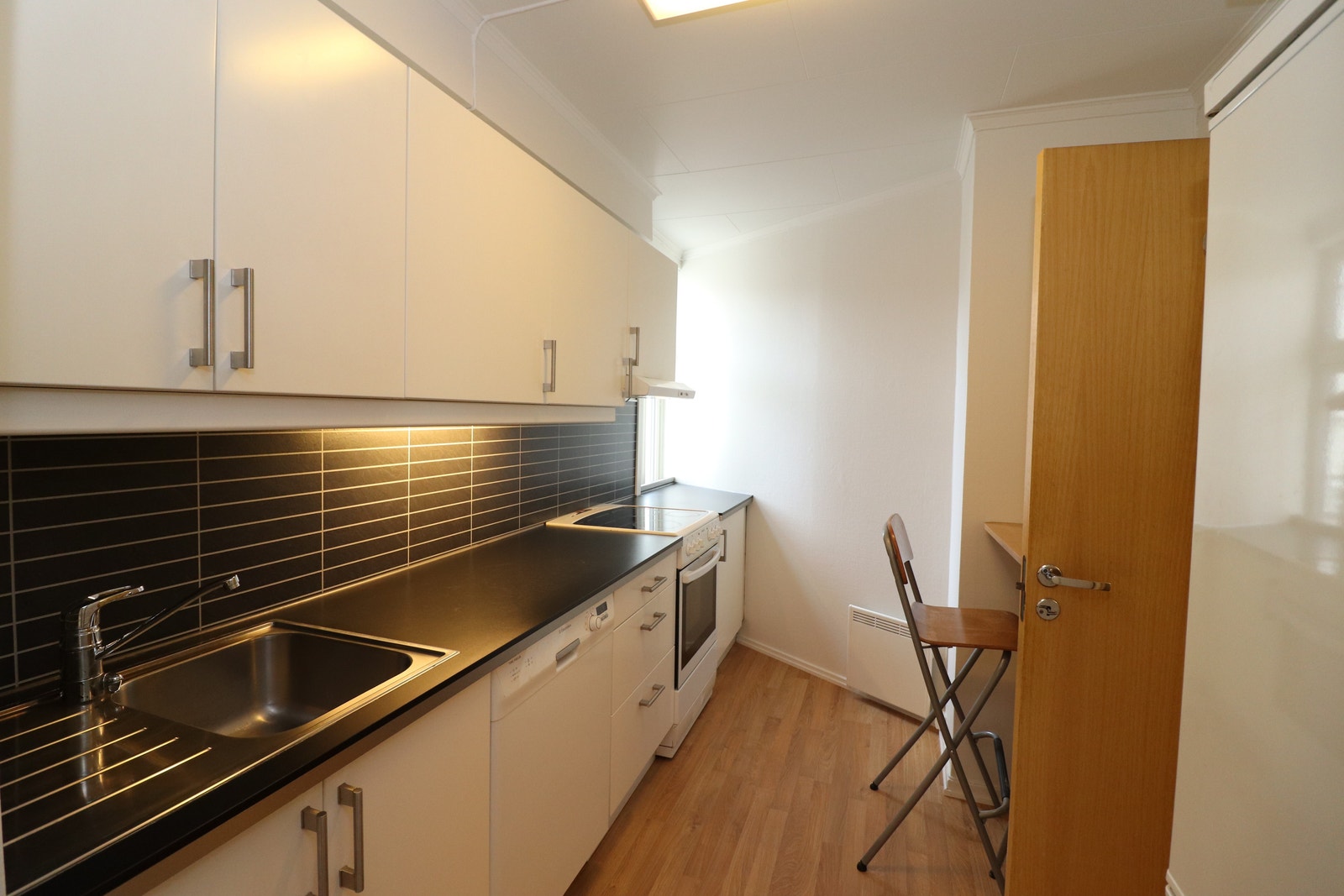 Kjøkken med kombiskap(kjøl/frys), komfyr og oppvaskmaskin. Galleribilde