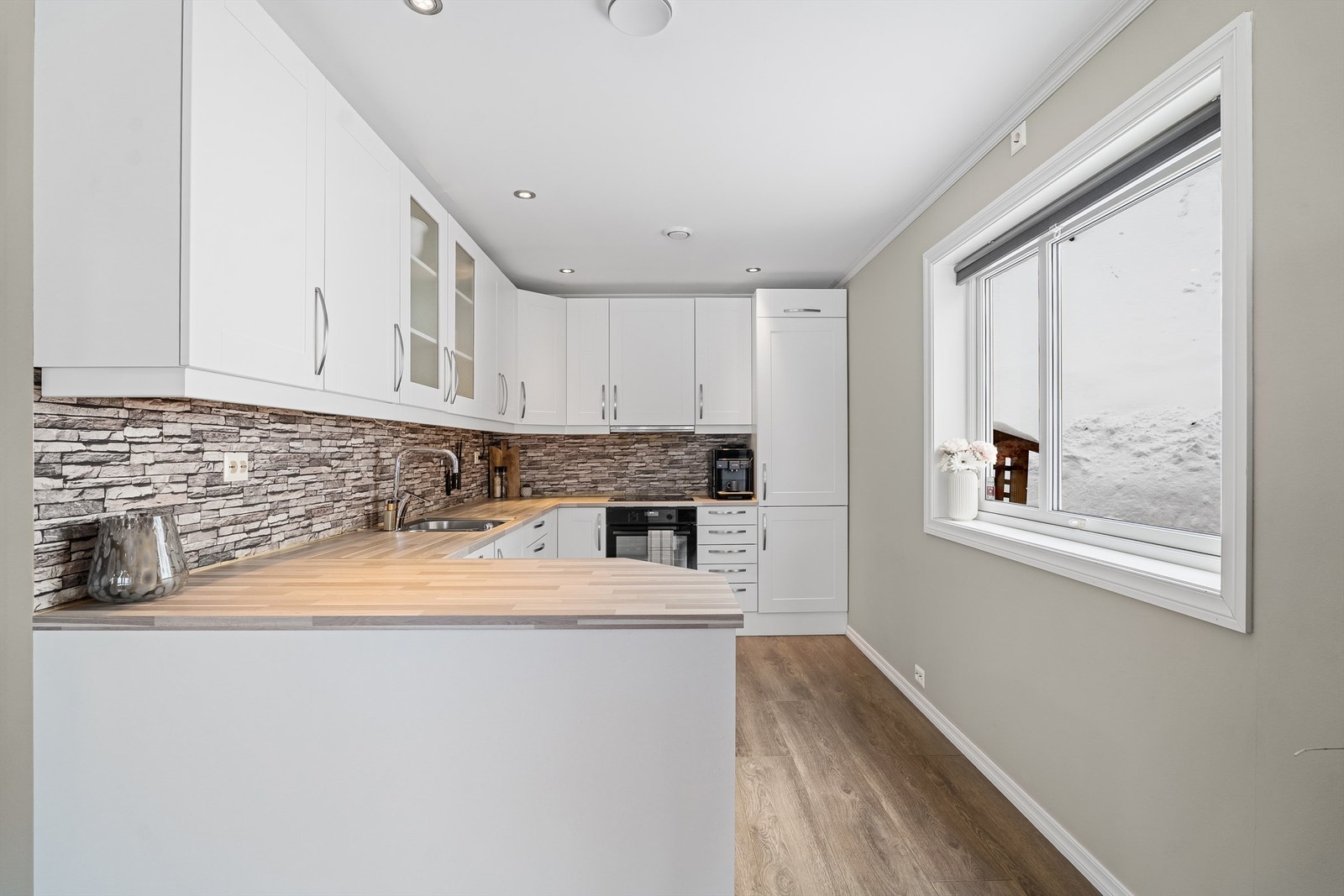 Lyst kjøkken med god benk- og skapplass Galleribilde