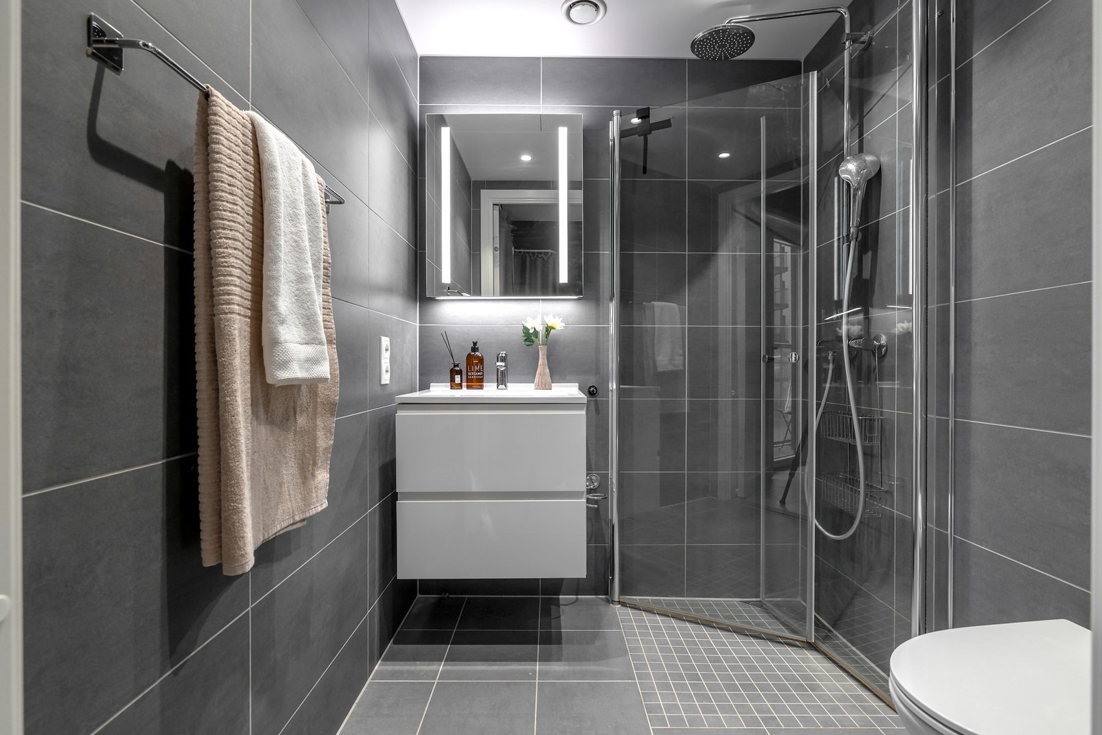 Badet med adkomst fra hovedsoverommet har servantinnredning med to skuffefronter samt speil med belysning Galleribilde