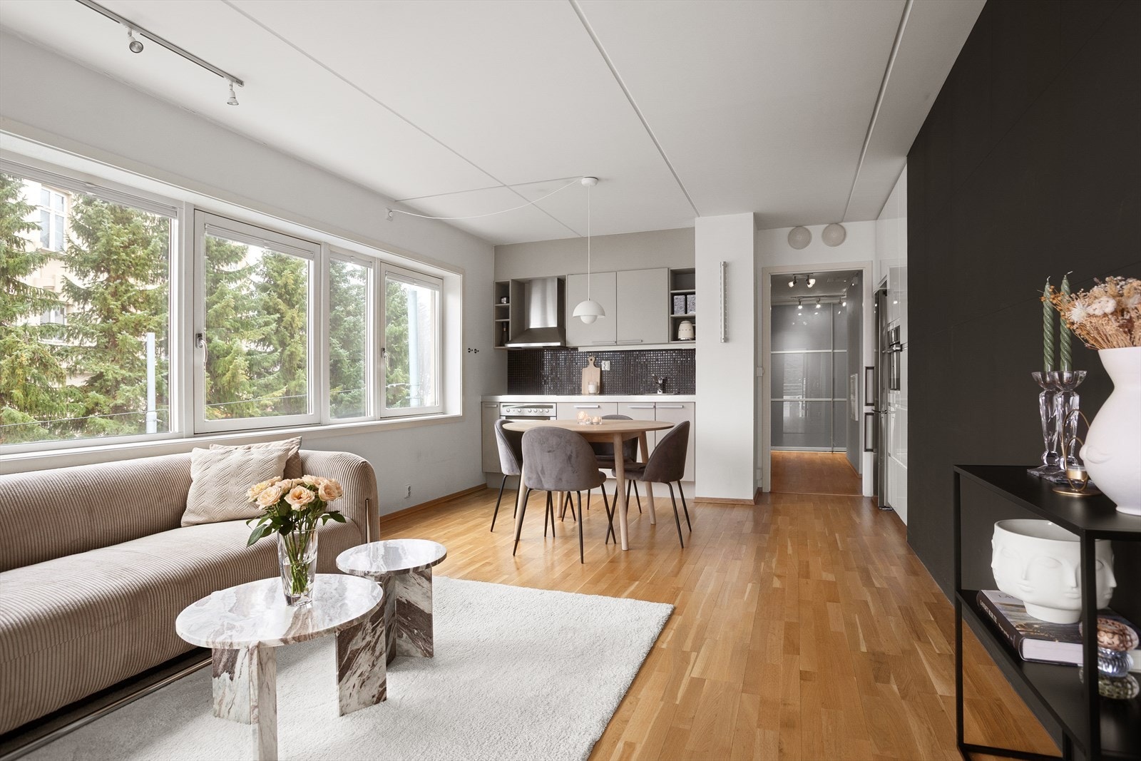 Den åpne løsningen mellom stue og kjøkken skaper et lyst og sosialt allrom Galleribilde