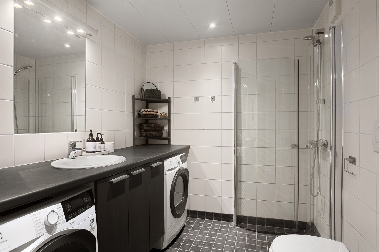 Pent flislagt baderom med varme i gulv og downlights i himling Galleribilde