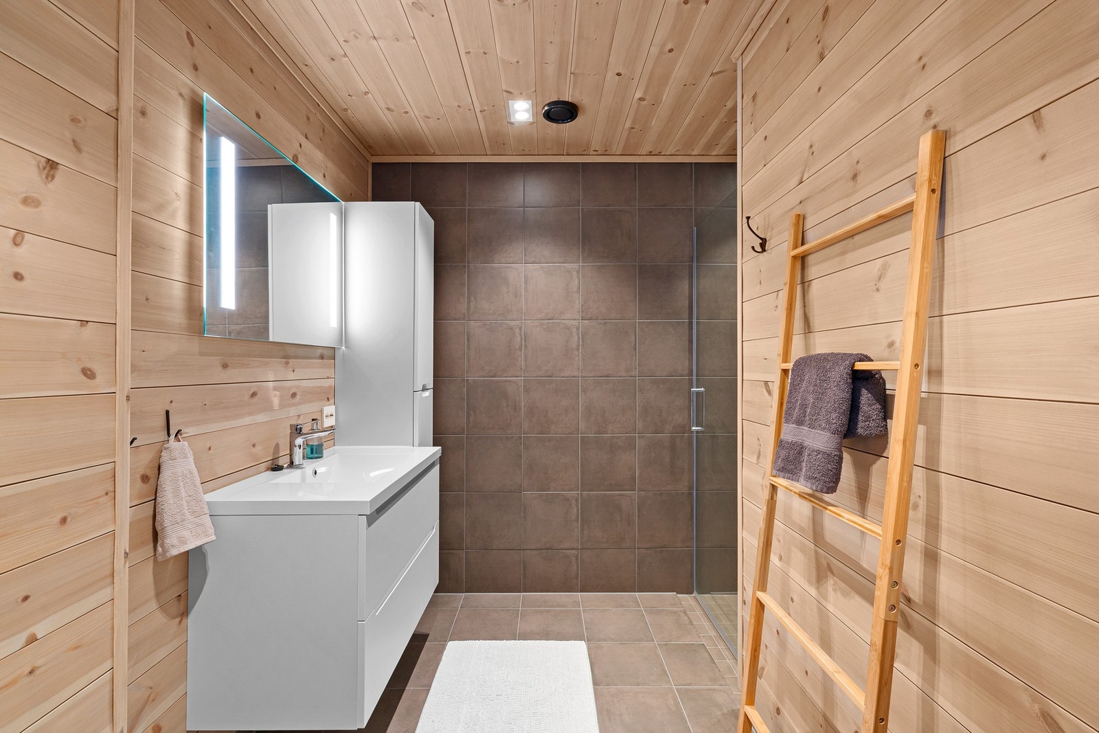 Stilrent bad med romslig dusjhjørne og gulvvarme. Galleribilde