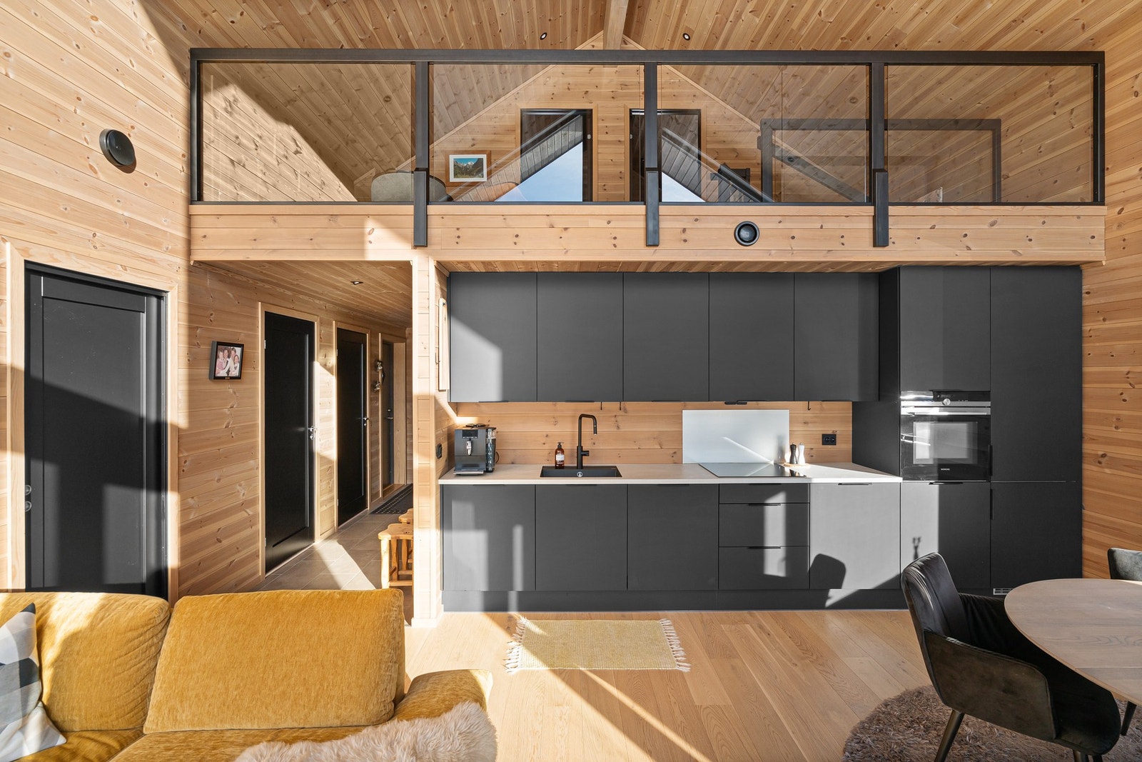 Hytten har et gjennomgående uttrykk med sorte detaljer og parkett på gulv. Galleribilde