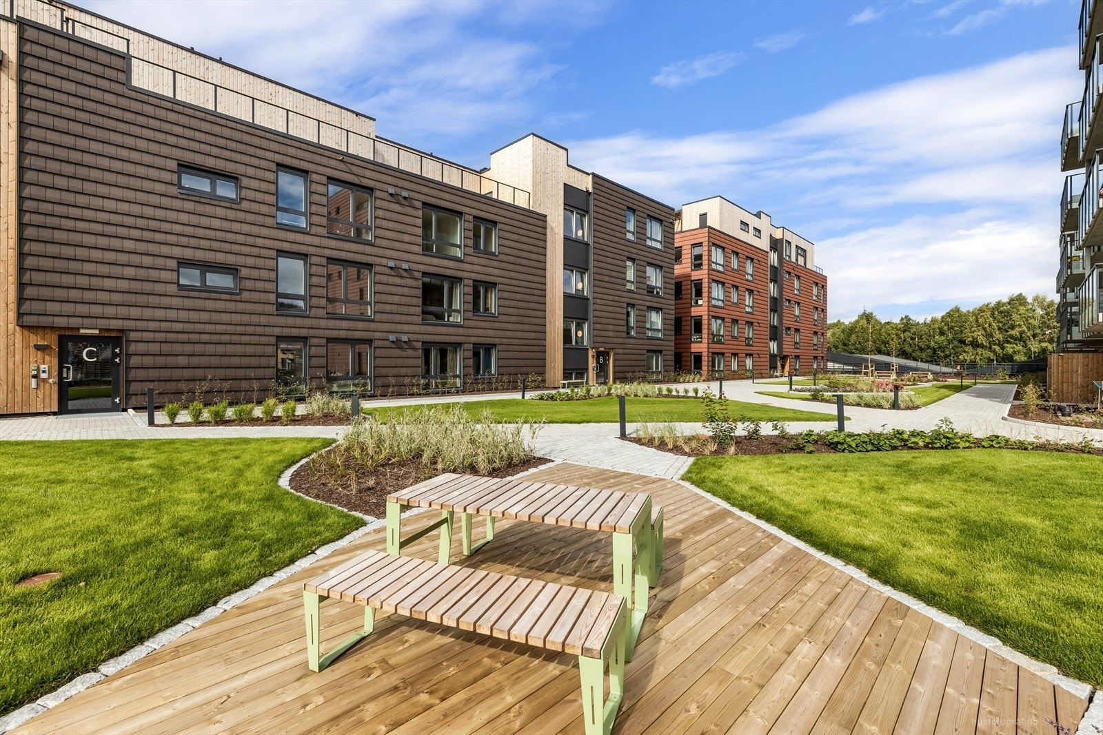 Området er opparbeidet med gangveier, sitteplasser, plener og plantefelt, samt lekeplass Galleribilde