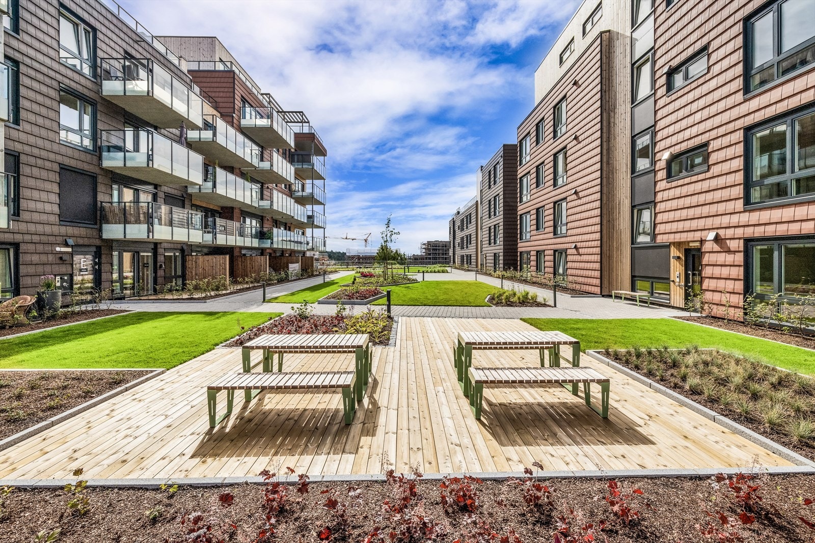 Området er opparbeidet med gangveier, sitteplasser, plener og plantefelt Galleribilde