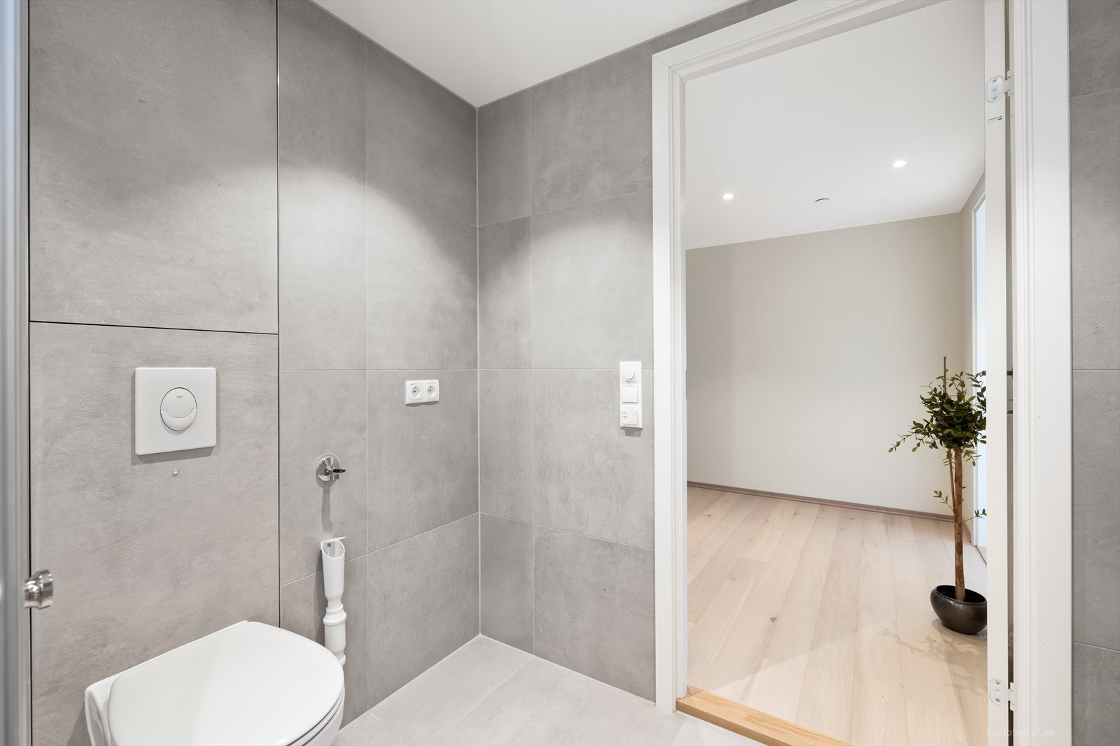 Badet er lekkert og delikat innredet med flislagte overflater og varmekabler i gulvet Galleribilde