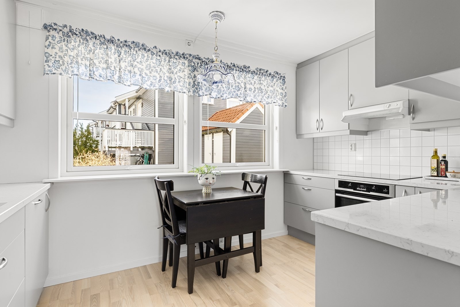 Innredningen er av grå slette fronter, stein benkeplate og våtromsplate på vegg over kjøkkenbenken for enklere rengjøring. Galleribilde