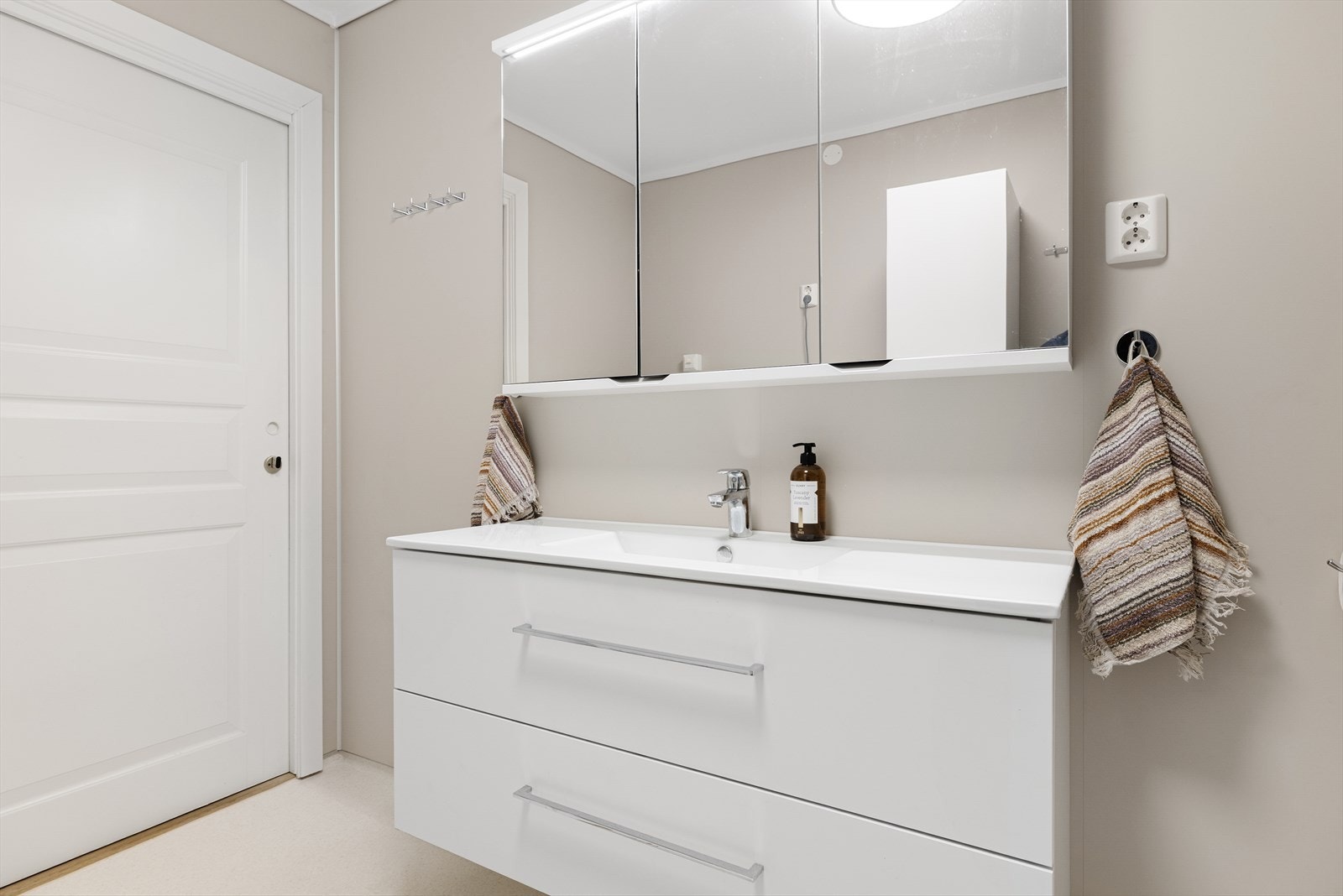 Det er innredet med stort servantskap, dusjkabinett, vegghengt toalett og opplegg for vaskemaskin samt tørketrommel. Galleribilde