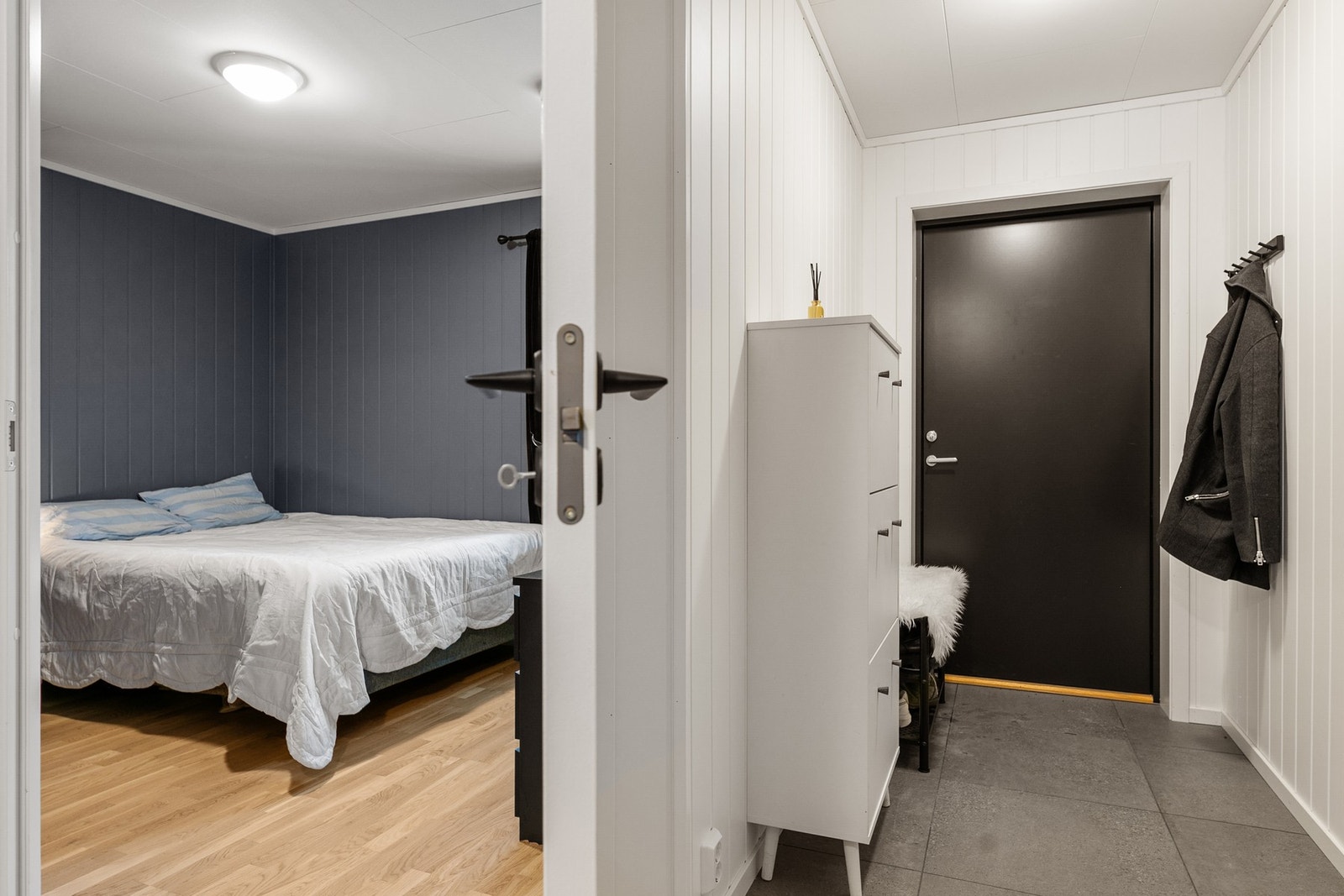 Entre med panelplater på vegger og fliser på gulv med gulvvarme. Galleribilde