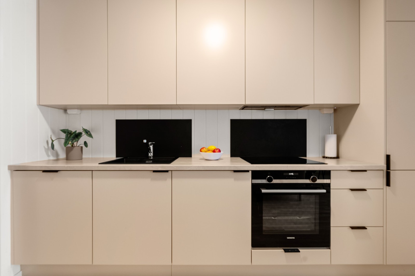 Kjøkken med beige, glatte fronter og laminat benkeplate med nedfelt oppvaskkum. Galleribilde
