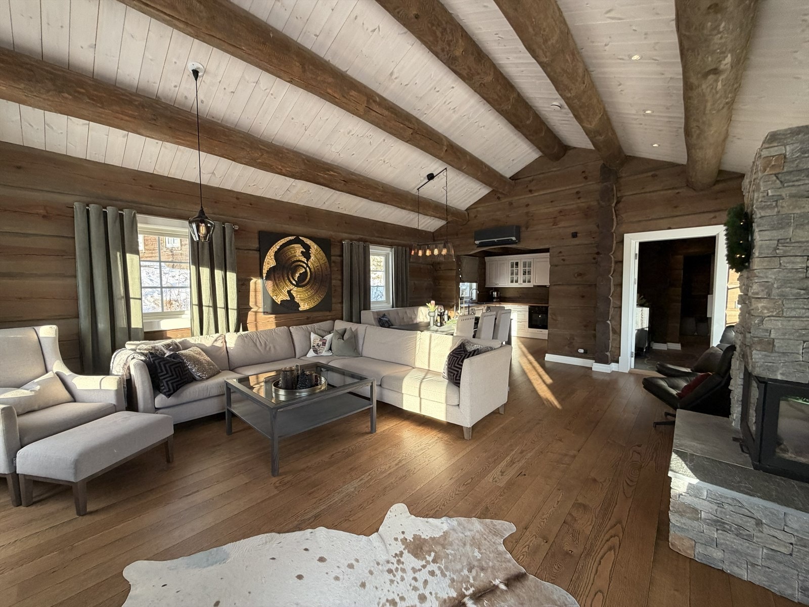 Romsleg stove med store vindaugsflater, vedovn og lekre detaljar. Galleribilde