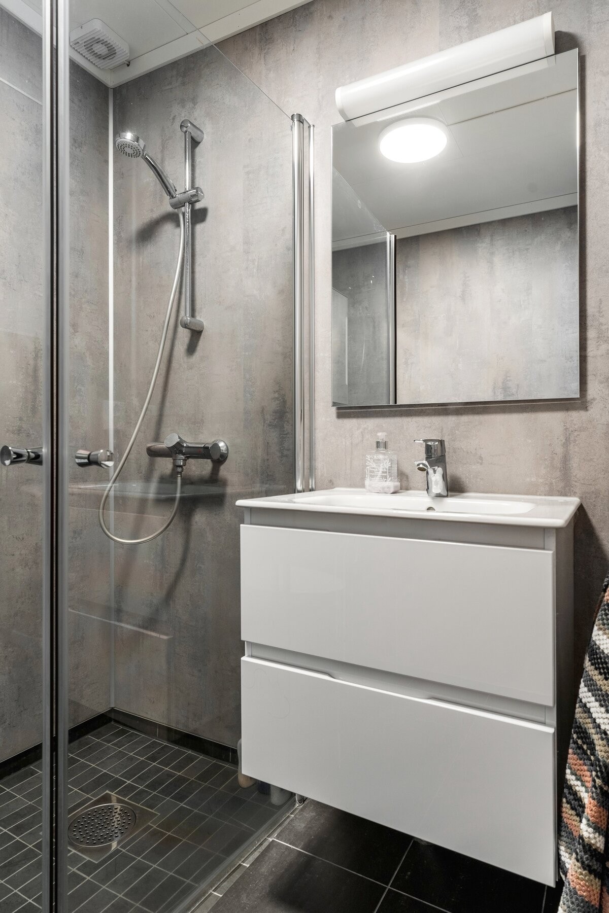 Badet er utstyrt med servantinnredning, servanttopp, toalett, dusjvegger og varmekabler. Galleribilde