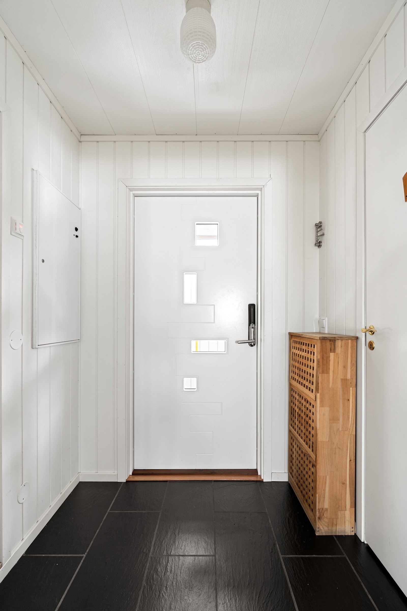 Velkommen inn! Innbydende entre med fliser på gulv, gulvvarme og nyere ytterdør i 2022