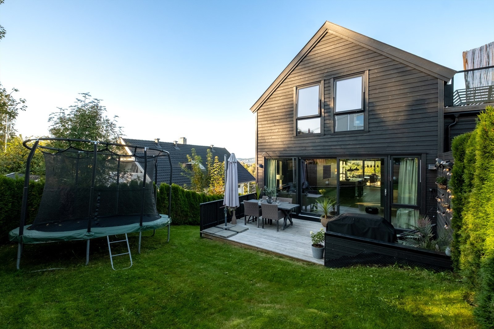 Bakhage med plen, platting og plass til trampoline. Galleribilde