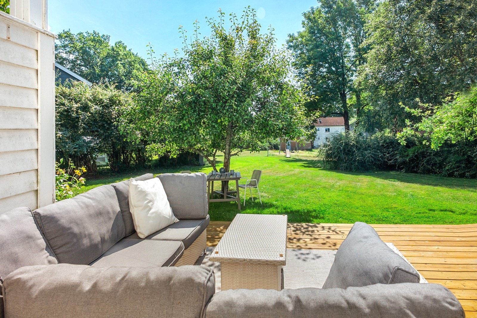 Fra verandaen fører kun noen få trappetrinn ned til terrassen. Her kan måltider nytes i skjermede og rolige omgivelser. Galleribilde