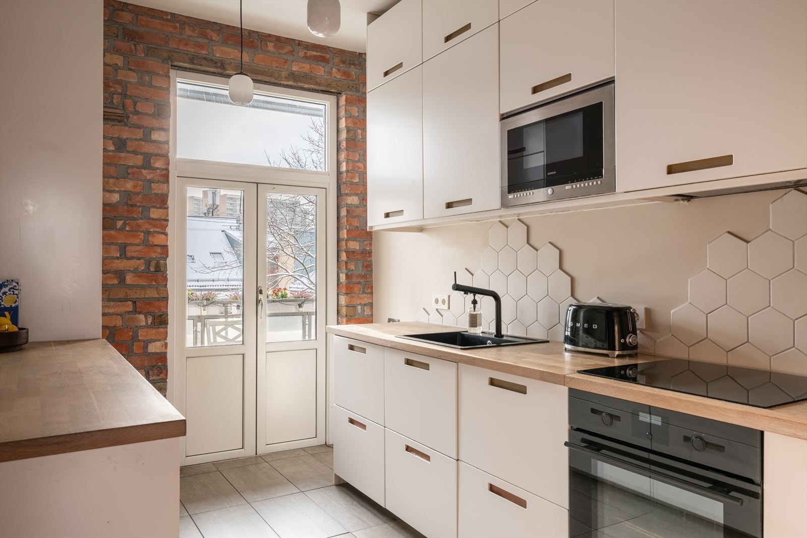 Fra kjøkkenet har tilgang til romslig balkong via dobbeltdør med store vindusflater Galleribilde