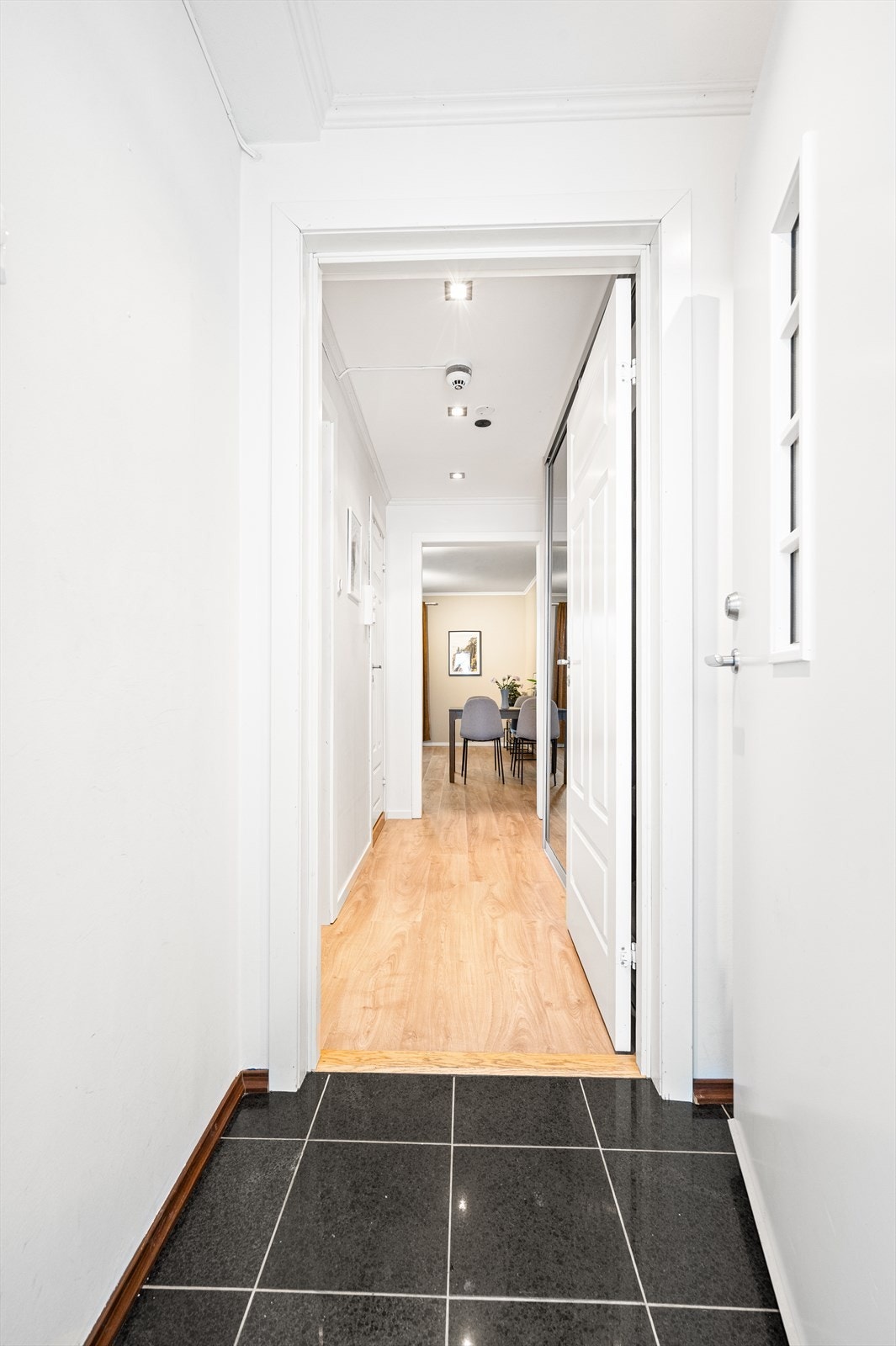 Entréen har flislagt gulv med elektrisk gulvvarme og leder deg videre inn i leiligheten. Galleribilde