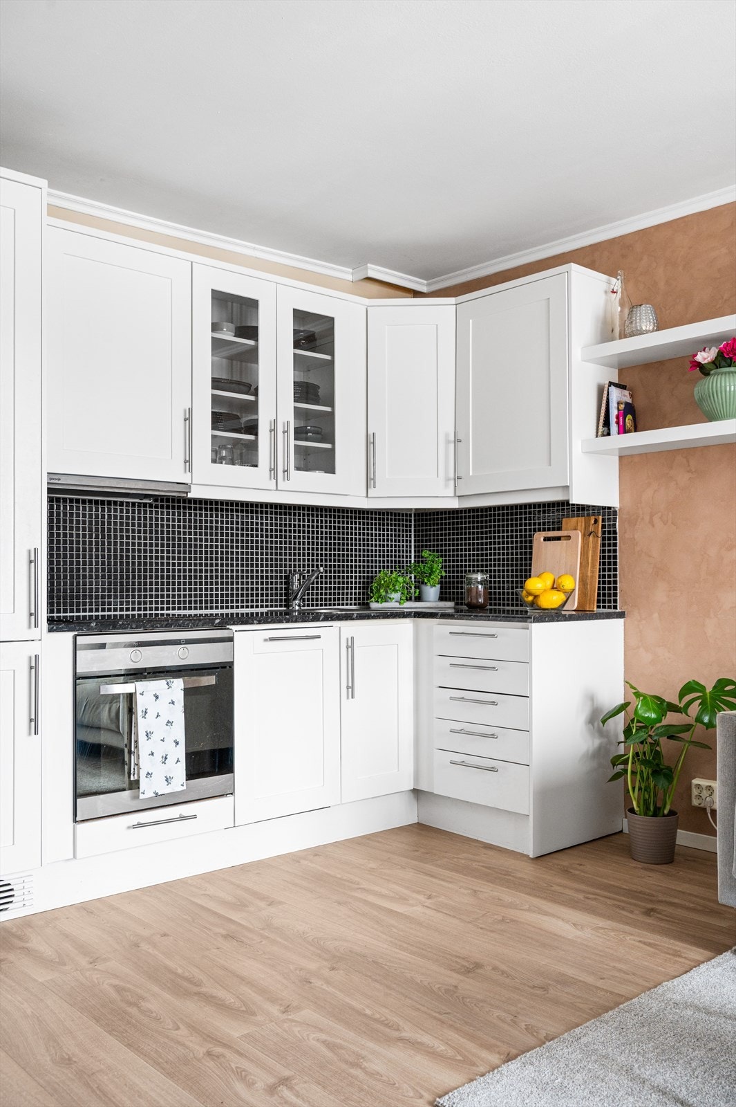 Kjøkkeninnredning med profilerte fronter, laminatbenkeplate og integrerte hvitevarer. Galleribilde