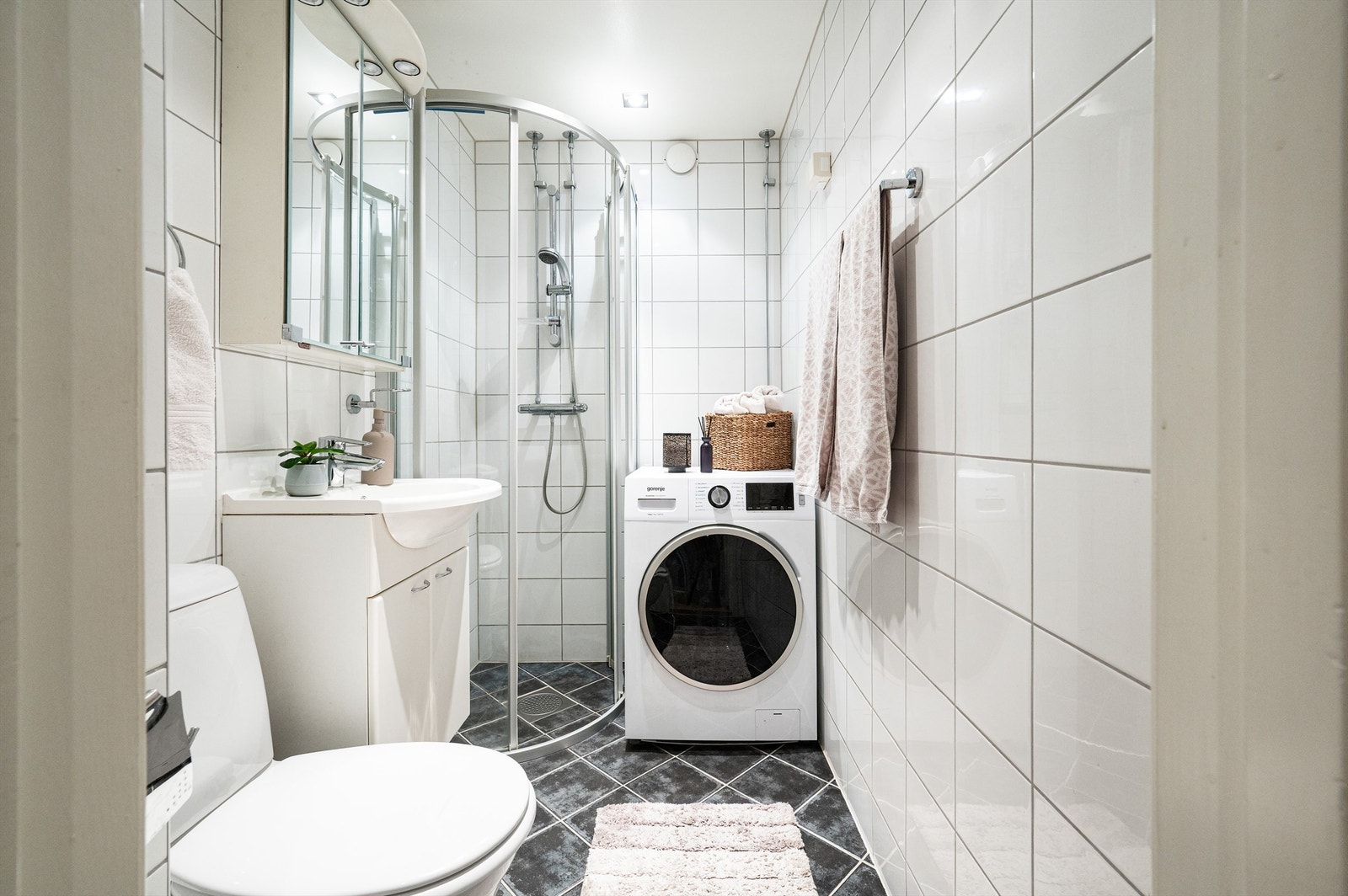 Badet er utstyrt med dusjhjørne, servantinnredning og har opplegg for vaskemaskin. Galleribilde