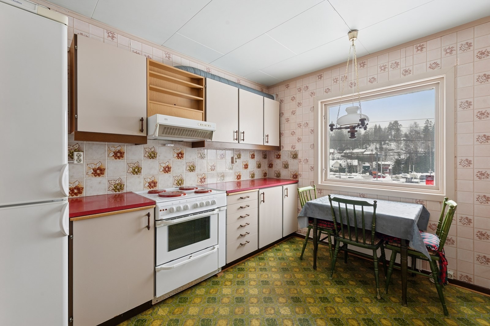 Kjøkkeninnredning av eldre alder med slette fronter, laminat benkeplate og ett-greps blandebatteri. Kjøkkenventilator med avtrekk ut. Galleribilde