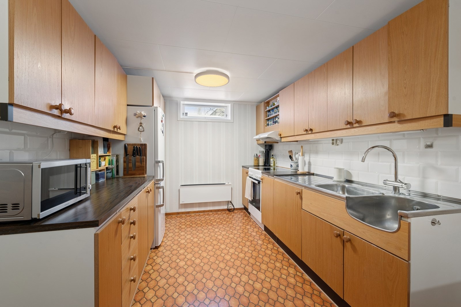 Kjøkkenet i hybeldelen er av eldre alder og utstyrt med slette fronter, laminat benkeplate og ett-greps blandebatteri. Kjøkkenventilator med kullfilter. Galleribilde