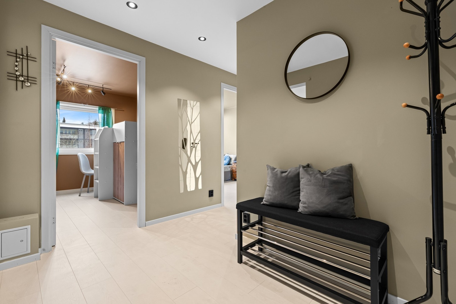 Lys gang med god takhøyde, veggmontert speil og knagger for yttertøy - funksjonelt og oversiktlig. Galleribilde