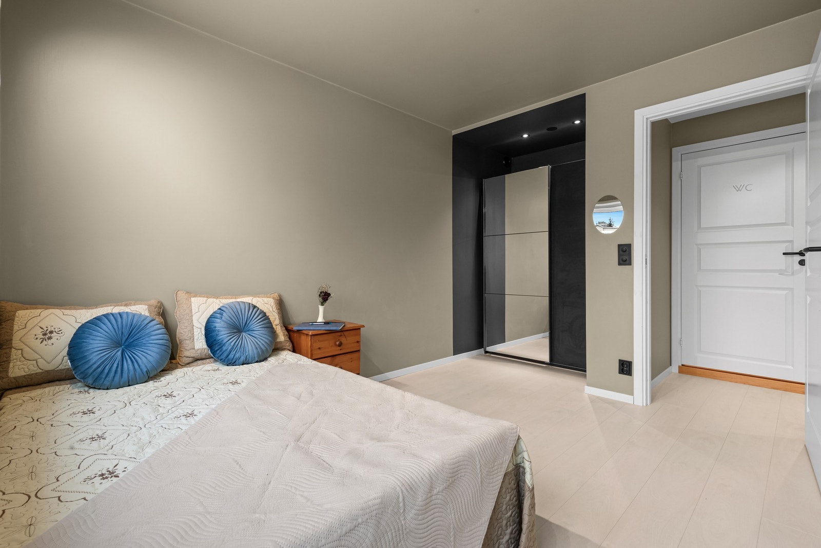 Soverom med garderobeløsning og rolige fargetoner som skaper en behagelig og avslappende atmosfære. Galleribilde